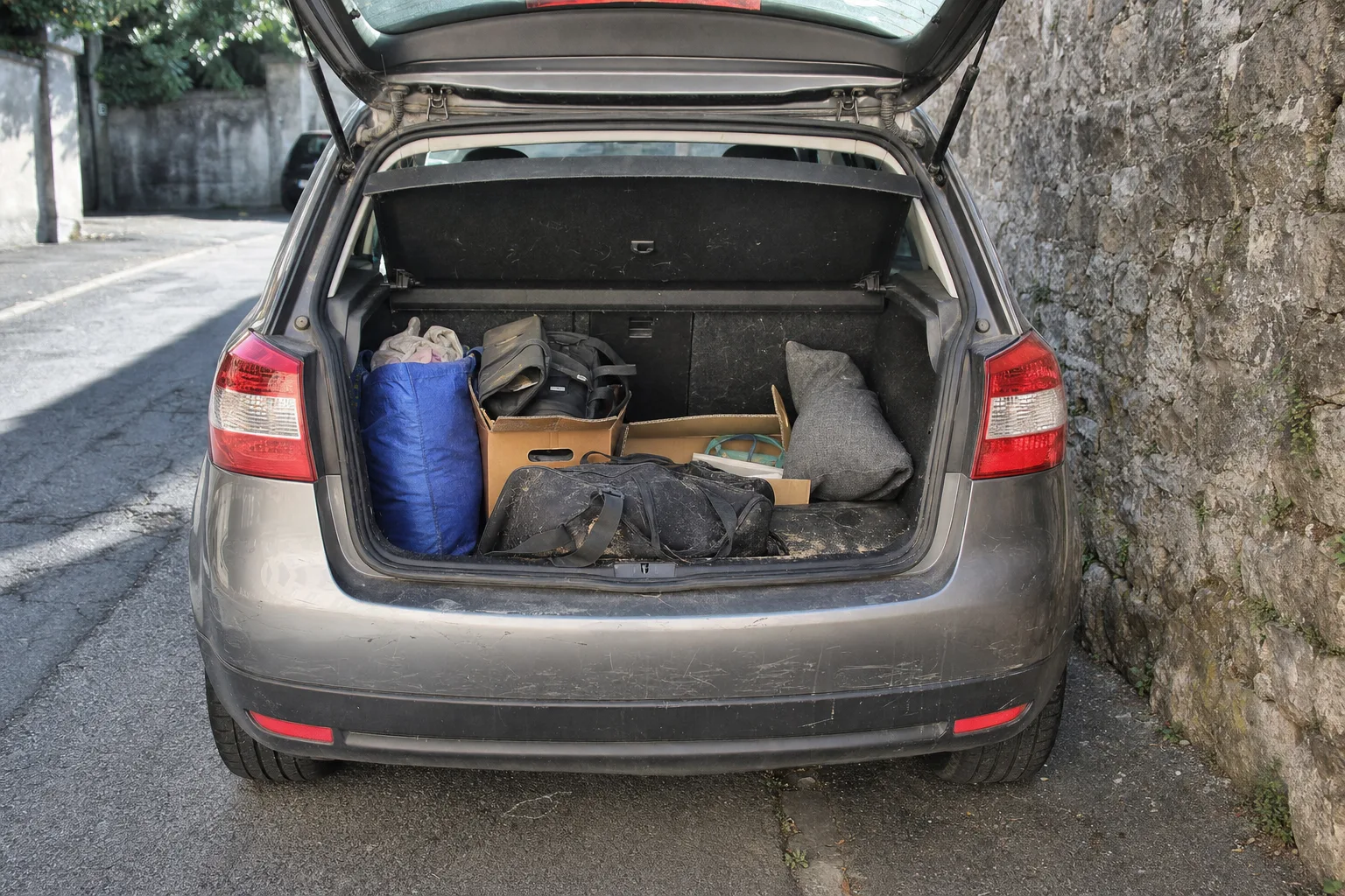 Remise en état de coffre à domicile à Caen — coffre avant intervention : moquette tachée, poils et sable incrustés, objets en désordre.